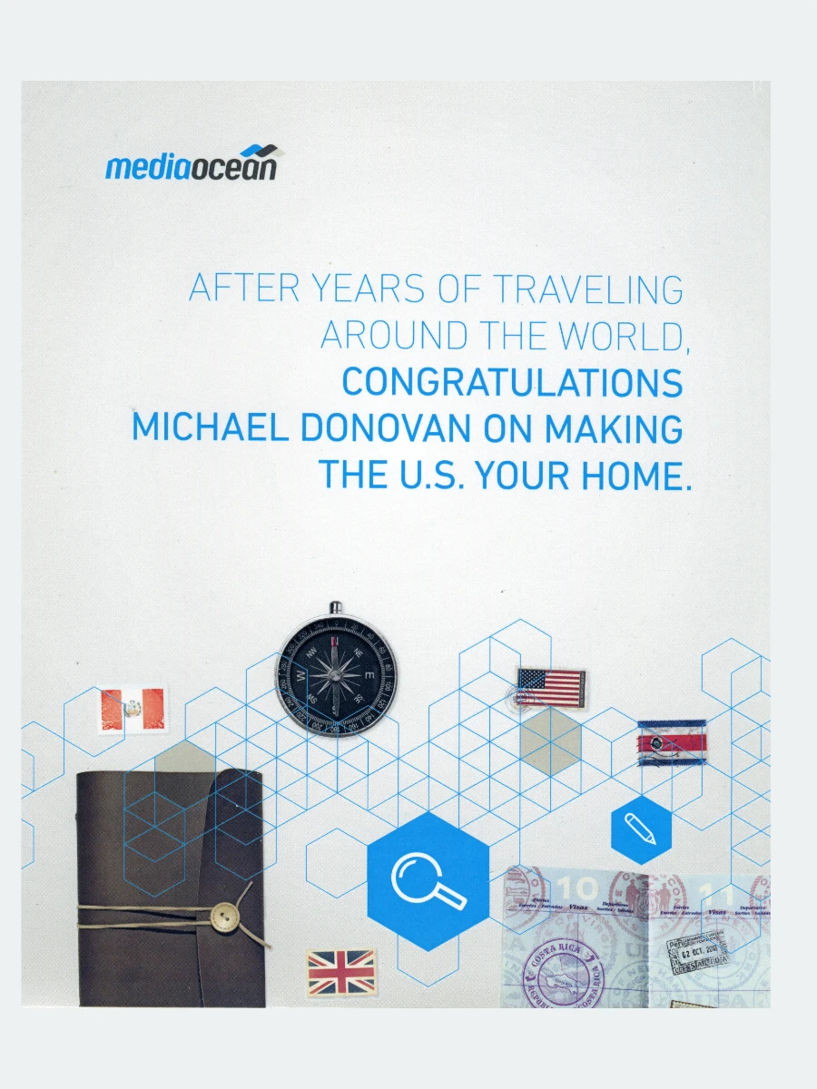 Digital image featuring the mediaocean company logo, travel related items such as a compass, and flags of several countries. Blue text on a white background congratulates Michael Donovan on making the U.S. his home.